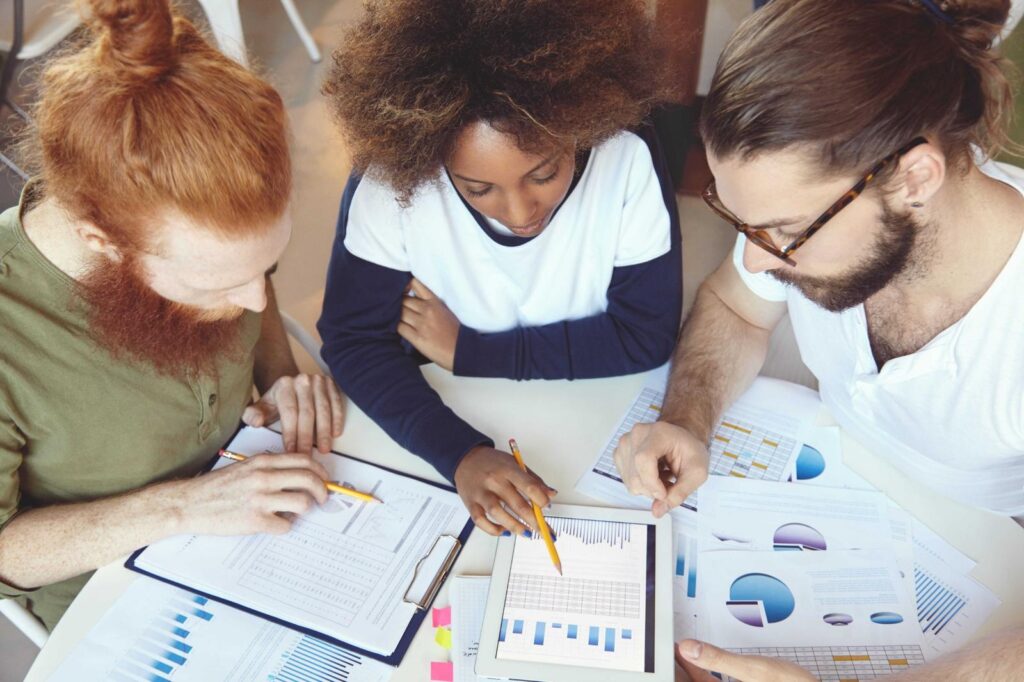 CX analysts reviewing customer metrics to determine what segments have satisfied customers
