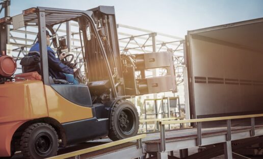 man driving a forklift into a delivery truck for a b2b company