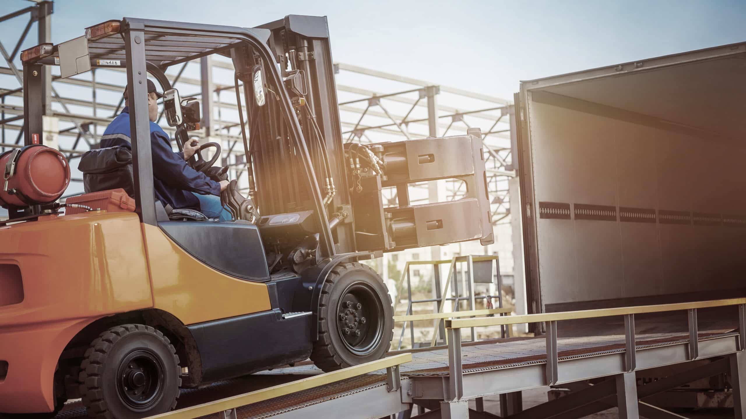 man driving a forklift into a delivery truck for a b2b company