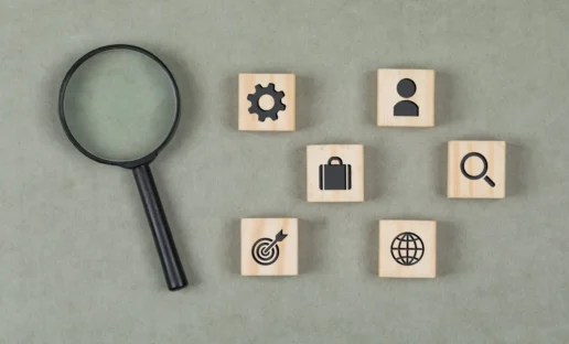 Financial concept with wooden cubes, magnifying glass on grey background flat lay.