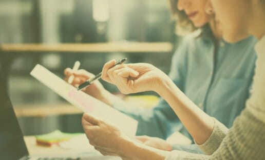 person holding pen and paper during an Interaction Metrics workshop